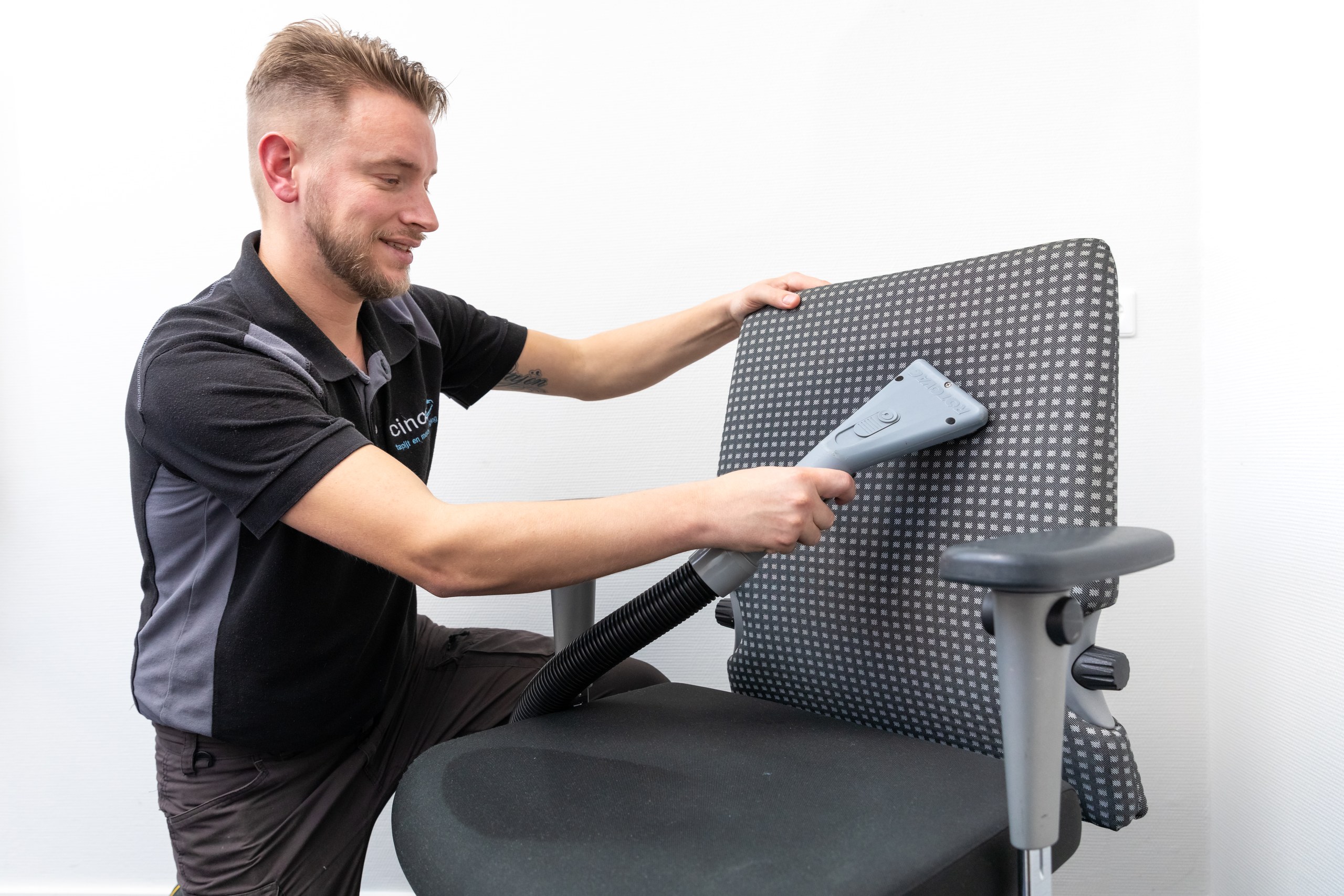 Vakspecialist reinigt de bekleding van een bureaustoel met een reinigingsmondstuk